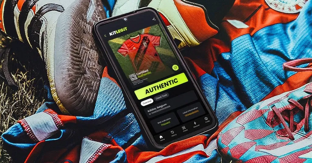 KitLegit mobile app lying on football shirts and Adidas Predator boot